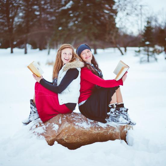 To kvinder i vinterlandskab med bøger